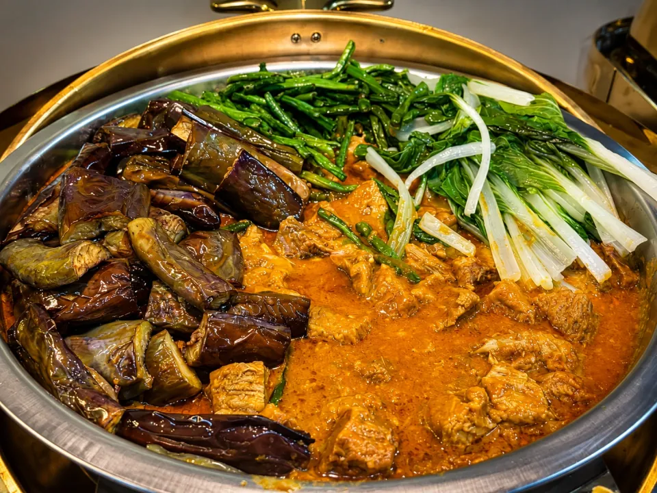 Beef kare-kare with vegetables and peanut sauce in a chafing dish